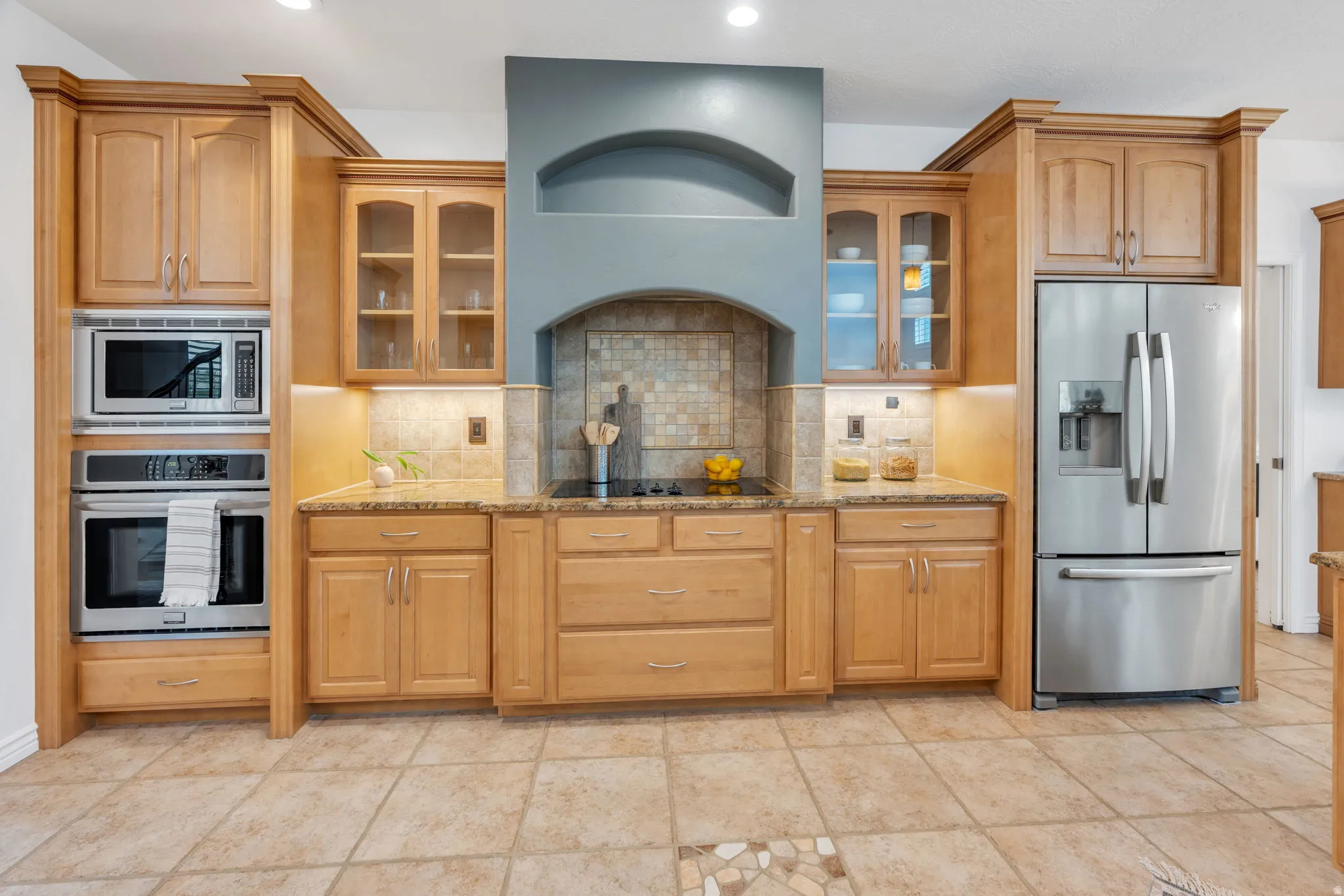 Beautifully appointed kitchen with rich wood cabinetry, granite countertops, a spacious breakfast bar, and an open design that flows seamlessly into the great room—perfect for everyday living and entertaining.