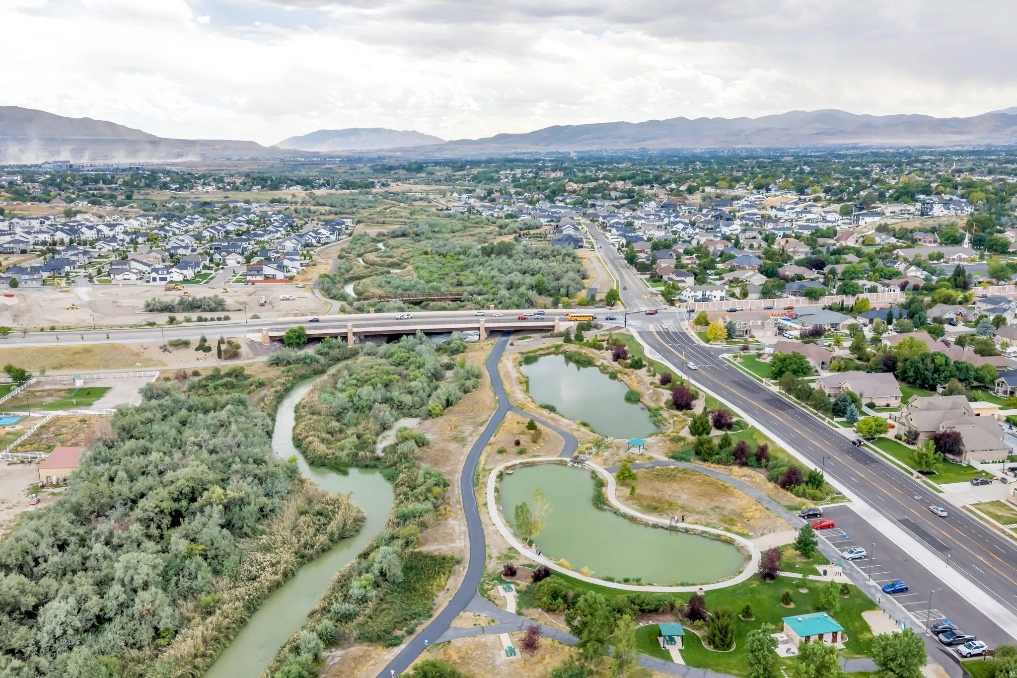Neighborhood setting with established residential areas, a prominent roadway, and a waterway with adjacent walking paths