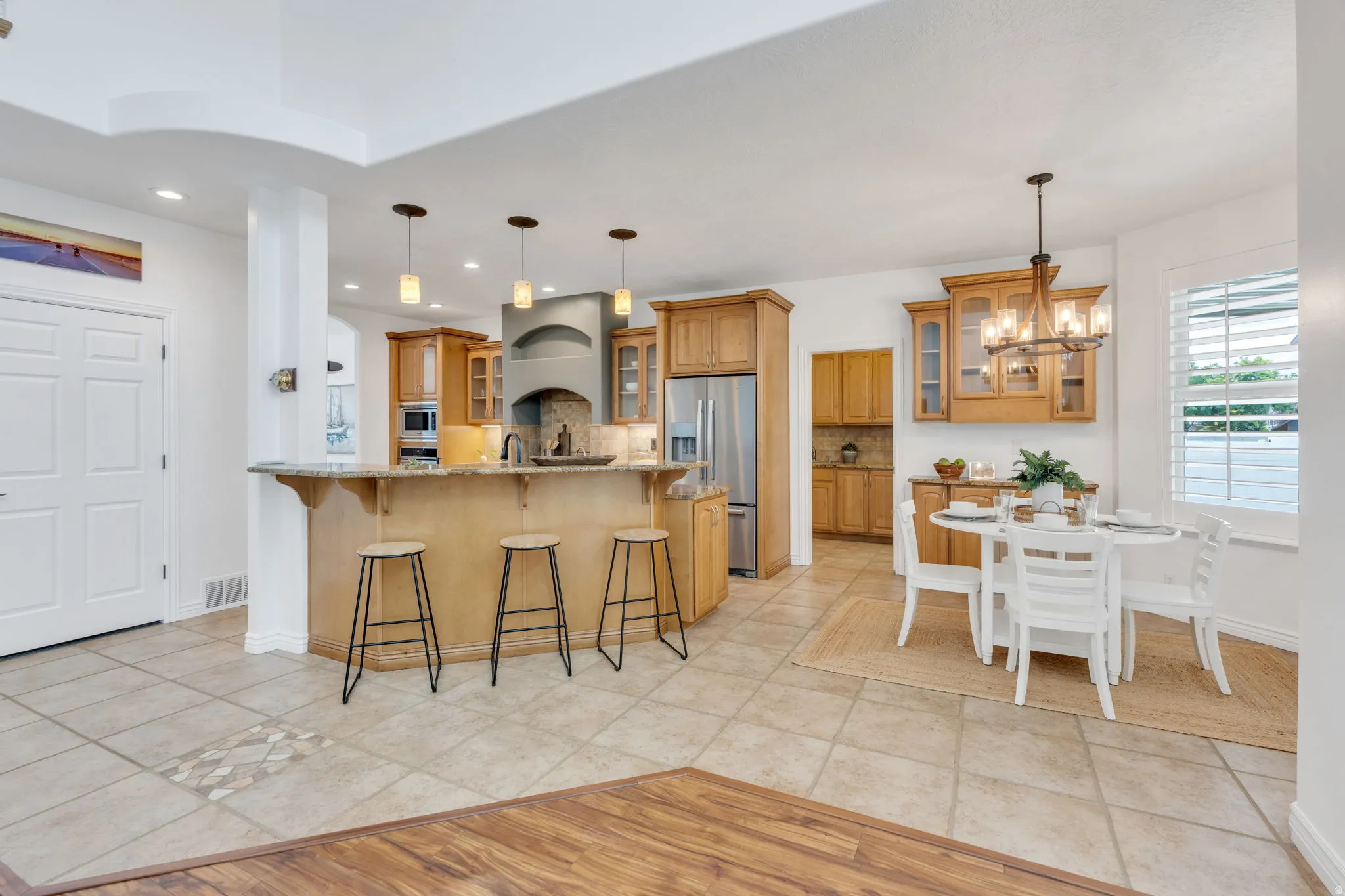 U-shaped kitchen with wood cabinetry, stainless steel appliances, and a breakfast bar