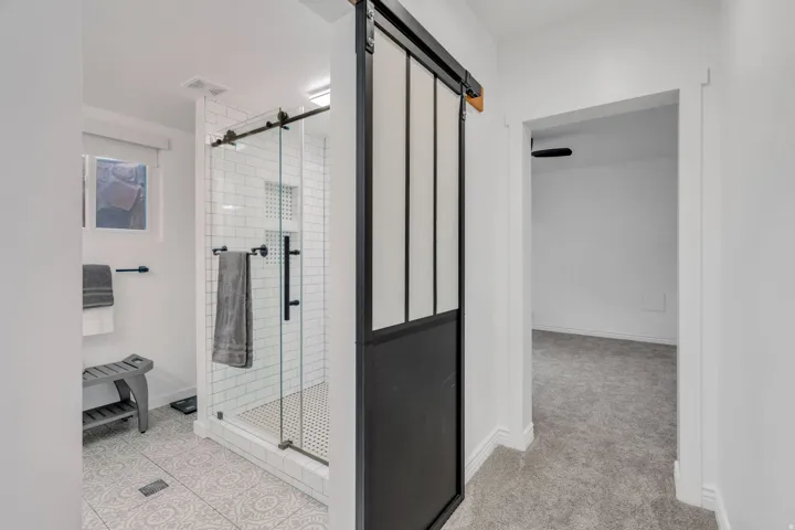 Custom updates shine in this basement bath, from the sleek Euro-style shower to the distinctive sliding barn door.