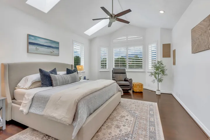 Beautiful primary suite with a vaulted ceiling, skylights, updated floors, and walls of windows with mountain views that fill the room with natural light.