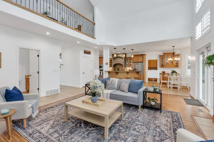 Soaring ceilings, hardwood flooring, and a kitchen with warm wood cabinetry
