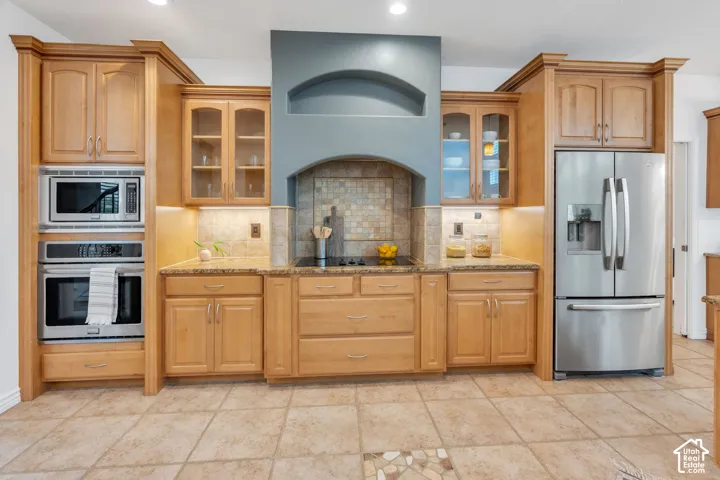 Beautifully appointed kitchen with rich wood cabinetry, granite countertops, a spacious breakfast bar, and an open design that flows seamlessly into the great room