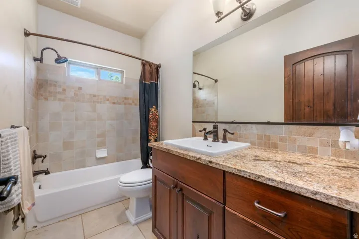 Built-in vanity with a surface-mounted sink, countertop, and dark wood-finish cabinetry