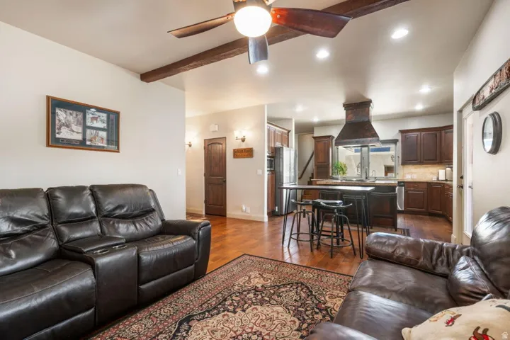Wood-finish flooring throughout, featuring a kitchen with dark wood cabinetry and a central island
