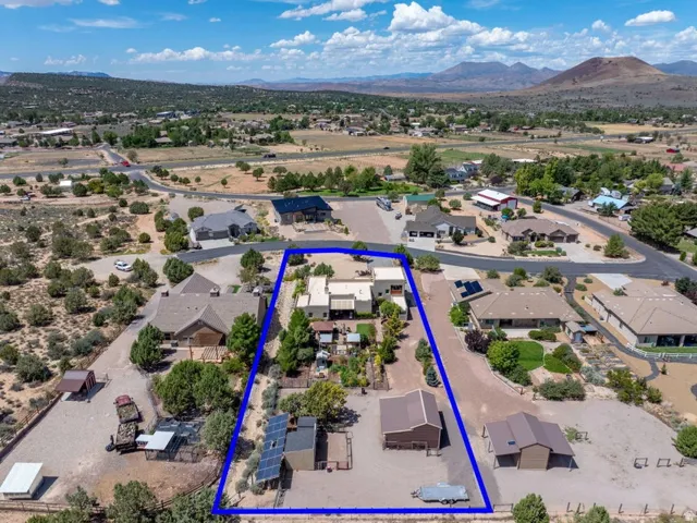 Expansive property featuring a main residence, detached garage, multiple outbuildings, and solar panels