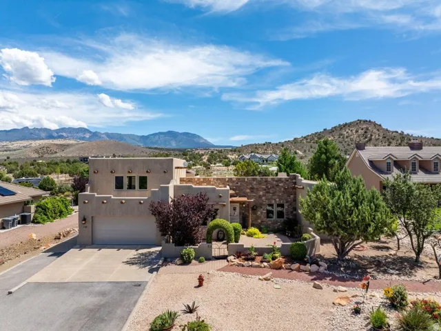 Southwestern-style stucco exterior with stone accents, a two-car garage, and desert landscaping
