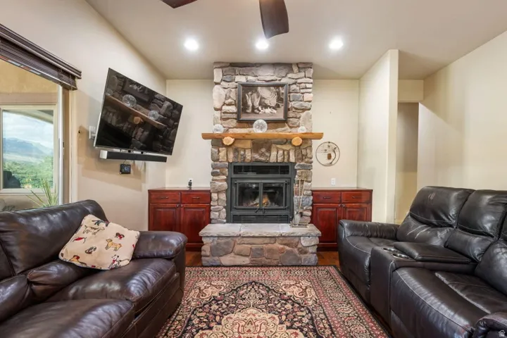 Stone fireplace with a log mantel, built-in hearth, and stone surround