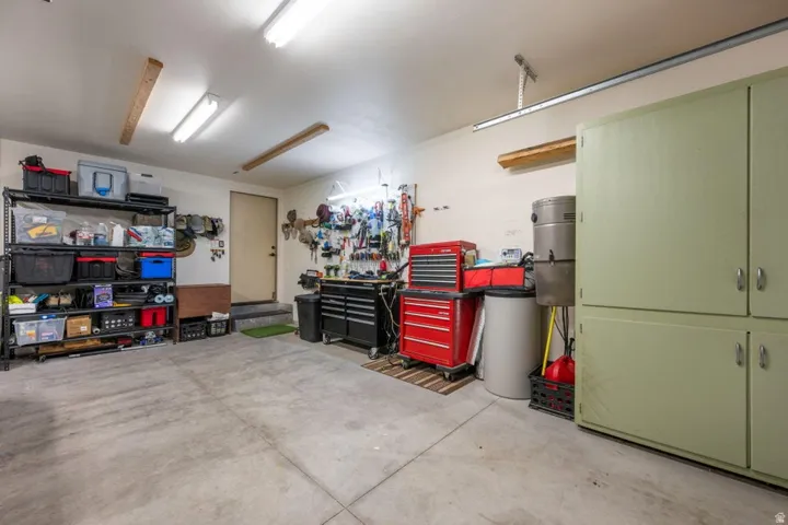 Concrete flooring, built-in cabinetry, and overhead fluorescent lighting
