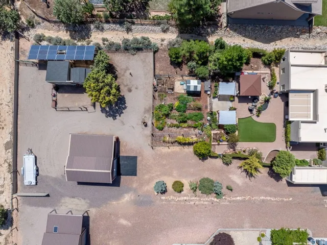 Expansive property featuring multiple outbuildings, solar panel array, and cultivated garden beds