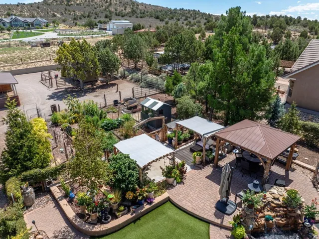 Expansive outdoor living area featuring a paved patio, a built-in gazebo, and a water feature