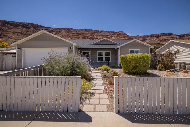 Single-story residence featuring a two-car garage, front yard landscaping, and a pathway leading to the entrance
