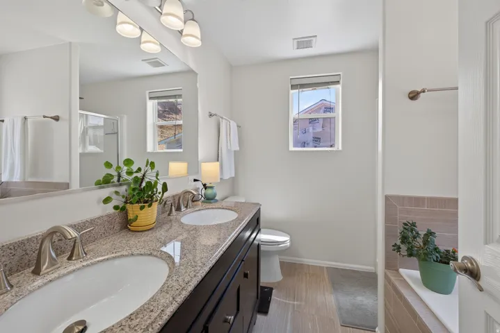 Dual vanity with light-toned countertop, undermount sinks, and brushed nickel fixtures