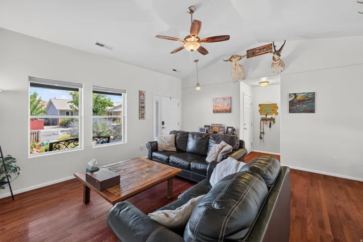 Vaulted ceiling with wood-finish fan, recessed lighting, and hardwood-style flooring