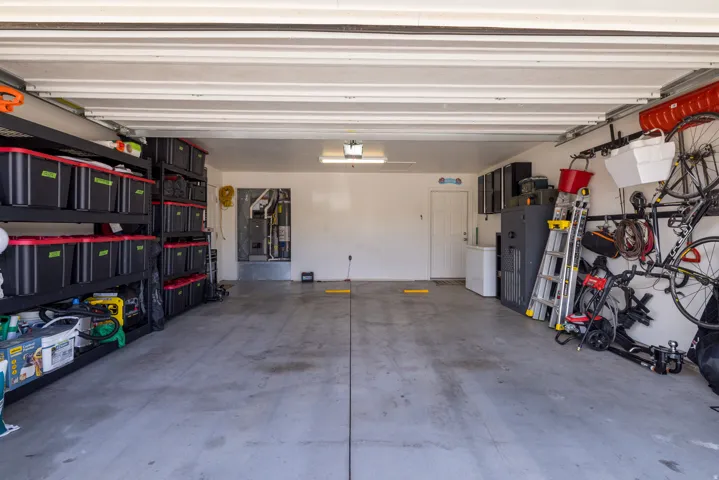 Spacious garage with concrete flooring, overhead lighting, and white walls