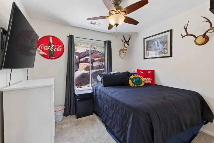 Carpet flooring, ceiling fan with integrated lighting, and a window with direct outdoor access