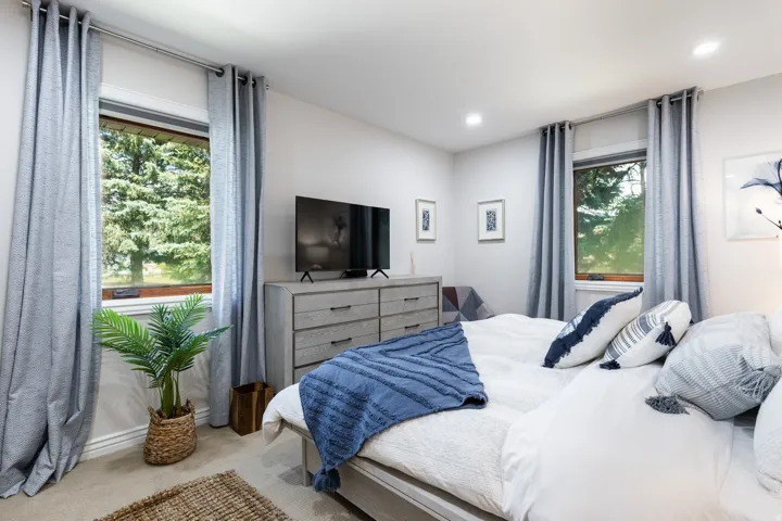 Recessed lighting, soft carpet flooring, and multiple windows with custom drapes