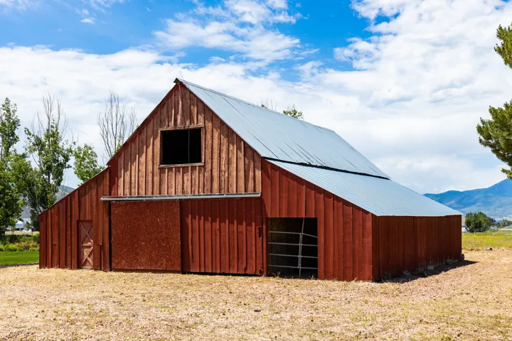 Red wood-sided barn structure with a metal roof
