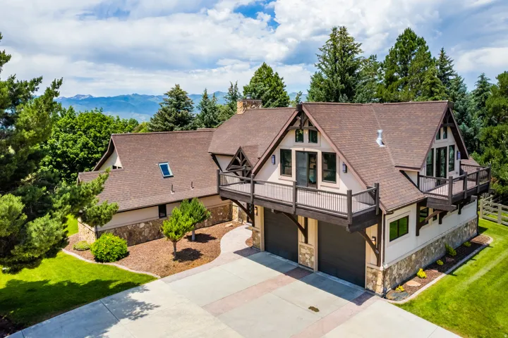 Craftsman-style residence with multiple gables, stone and stucco exterior, prominent balconies, and a multi-car garage
