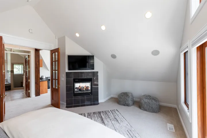 Angled ceiling with recessed lighting and integrated speakers