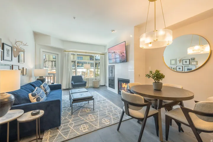 Expansive windows, wood-finish flooring, and a contemporary fireplace