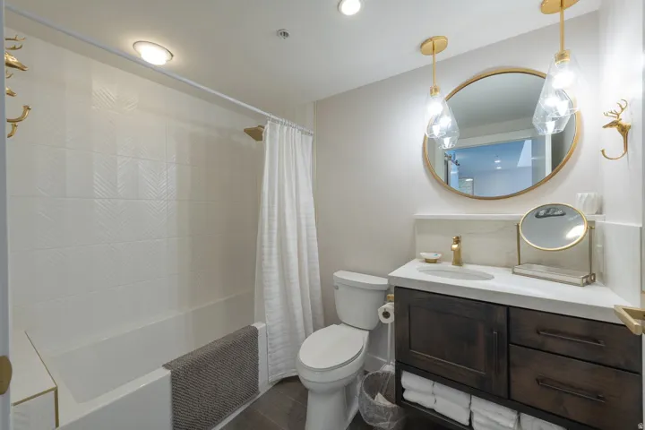 Bathroom featuring a vanity with dark wood-finish cabinetry, a white countertop, and an oval mirror