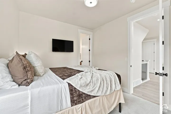Recessed lighting, wall-mounted television, neutral wall color, white trim, and light-toned flooring