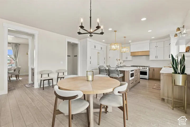 Open-concept kitchen and dining area featuring light wood like-finish flooring