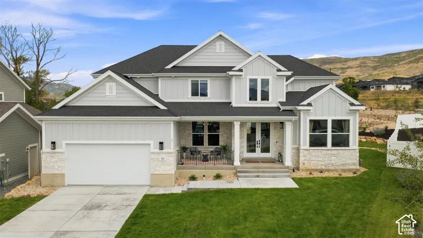 Contemporary exterior with light gray siding and white stone detailing