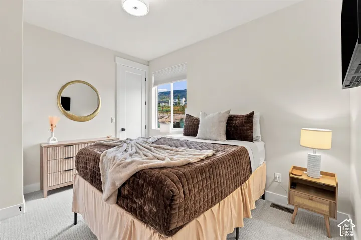 Recessed lighting, light-colored carpeting, white interior doors, and a window with a distant landscape