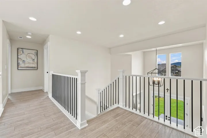 Hallway  Looks out over the entry way and great room! Featuring wood-finish flooring, recessed lighting, and a white and black spindle railing