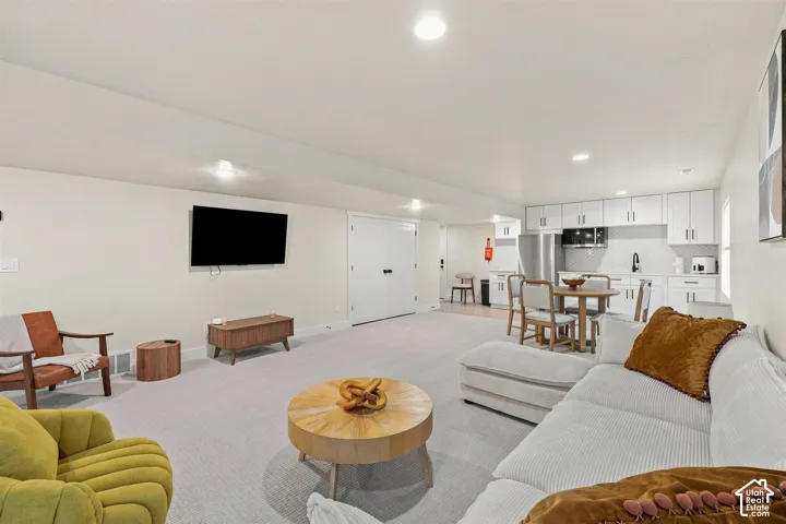 Recessed lighting, light-colored walls, white shaker-style cabinetry, stainless steel appliances, and a tiled backsplash