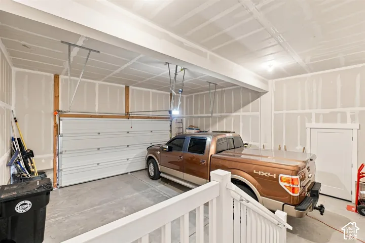 Attached garage featuring a concrete floor, automatic overhead door, and interior access door