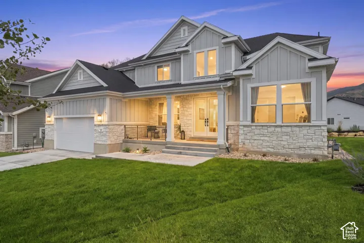 Contemporary gray exterior with stone accents, a covered front porch, and a two-car garage. Cul-de-sac location