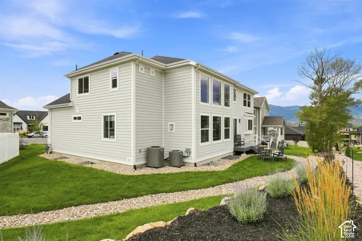 Two-story residence with light-toned siding and multiple large windows