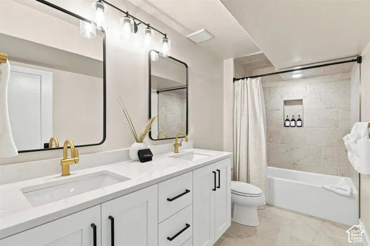 Dual vanity with white cabinetry and gold-finish faucets