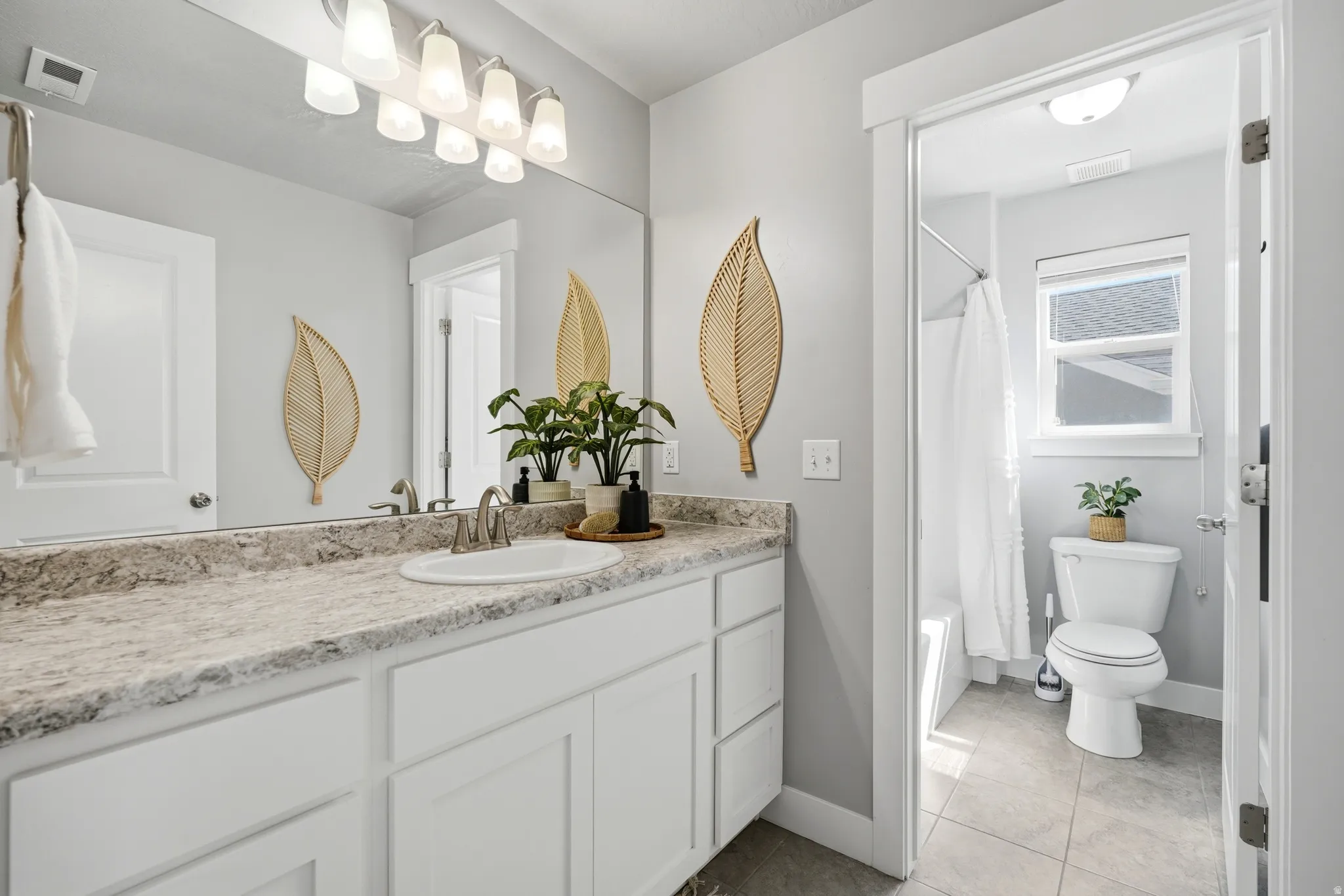 Vanity with stone-finish countertop, undermount sink, and brushed nickel faucet