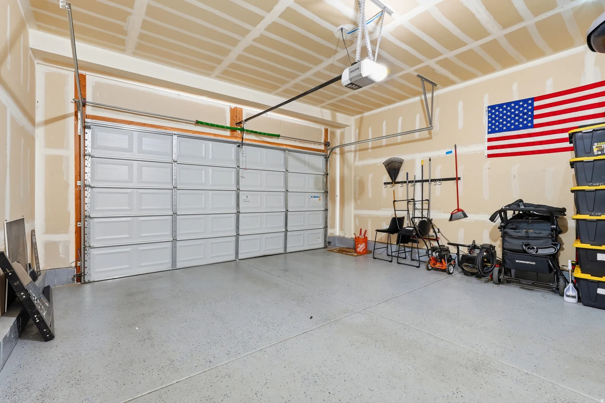 Attached two-car garage with an automatic garage door opener, concrete flooring, and exposed ceiling joists