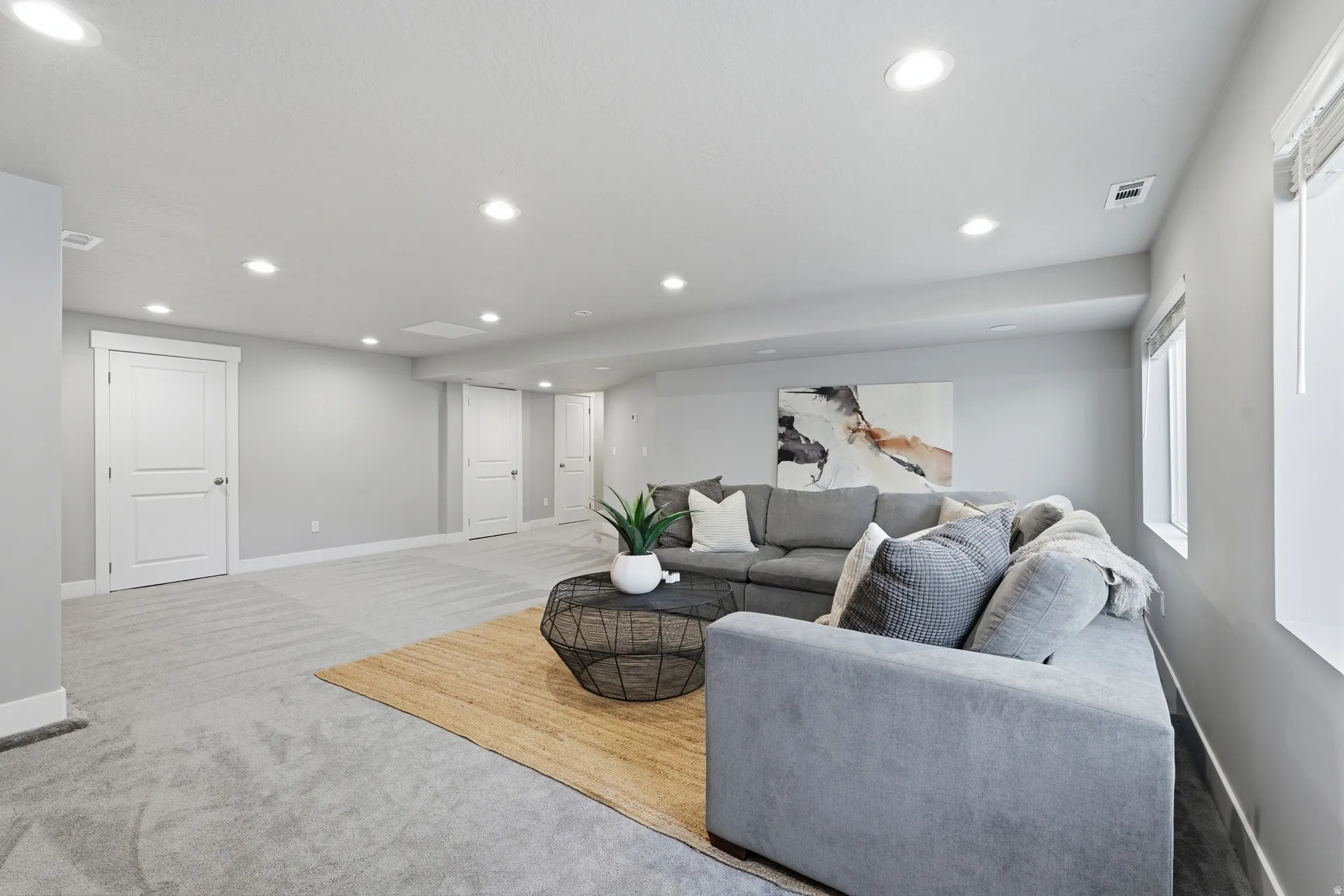 Recessed lighting, light gray wall finishes, light carpeting, white trim, and white two-panel interior doors
