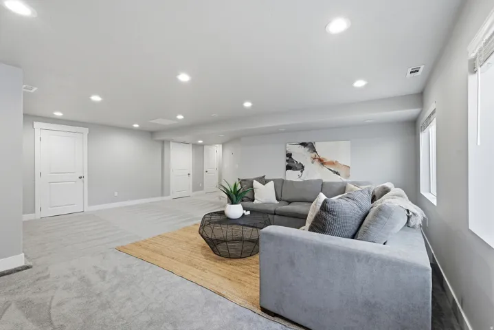 Recessed lighting, light gray wall finishes, light carpeting, white trim, and white two-panel interior doors