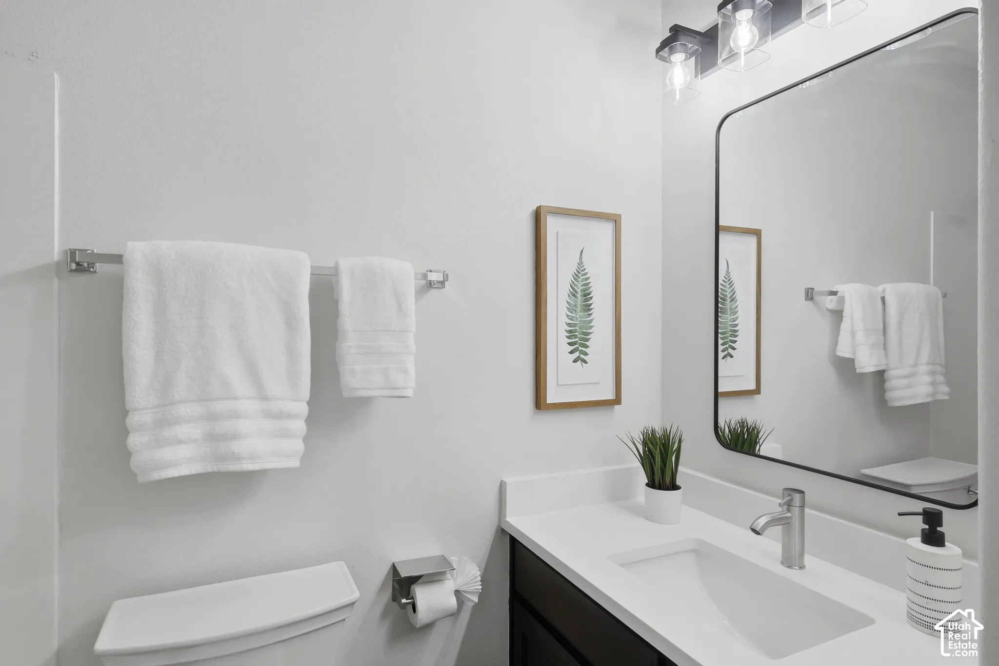 Modern vanity with a rectangular undermount sink, white countertop, and brushed nickel faucet