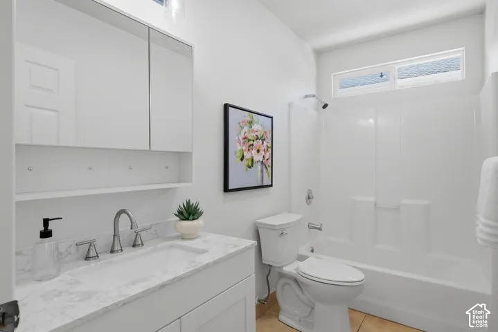 White vanity with a stone-finish countertop and undermount sink