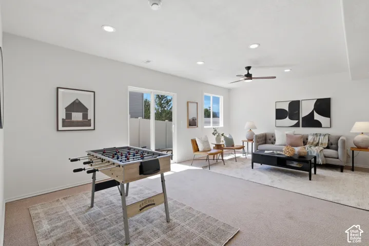 Recessed lighting, ceiling fan, sliding glass door, and two windows provide natural light
