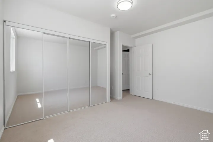 Neutral tone carpet flooring, white walls, and a contemporary flush mount light fixture