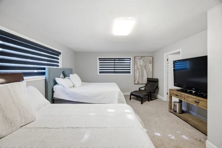 Spacious interior featuring two built-in beds, light gray walls, carpet flooring, and a flush mount ceiling light fixture