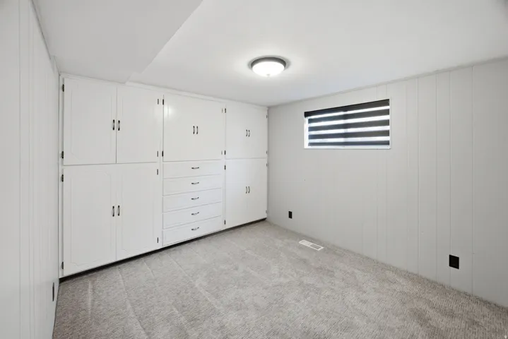 Built-in white cabinetry with various storage options, including drawers and cabinets