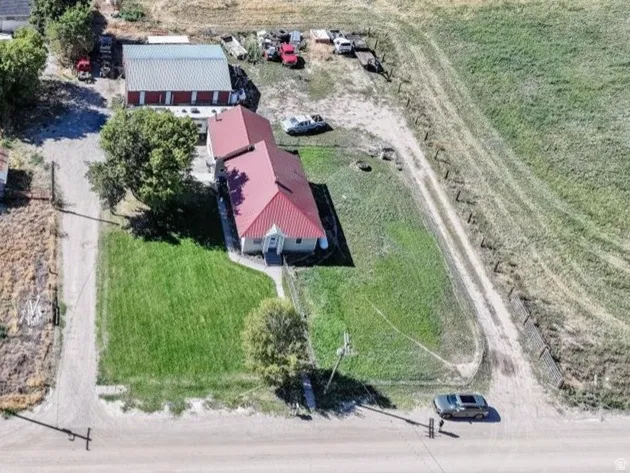 Expansive property featuring multiple structures, a main residence with a red roof, a large metal barn, and additional outbuildings