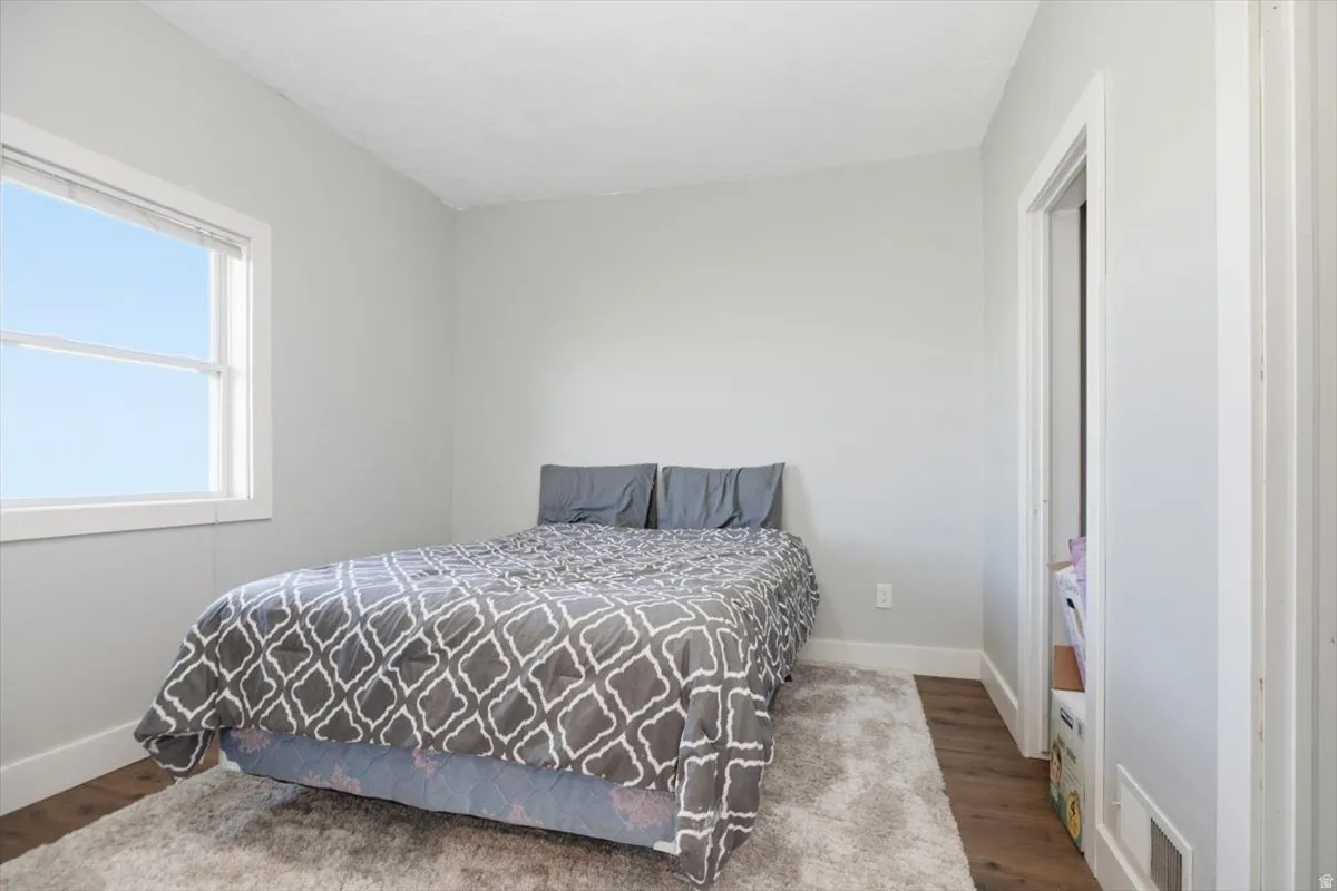 White window trim, light gray painted walls, wood-finish flooring, white door frame, and white baseboards