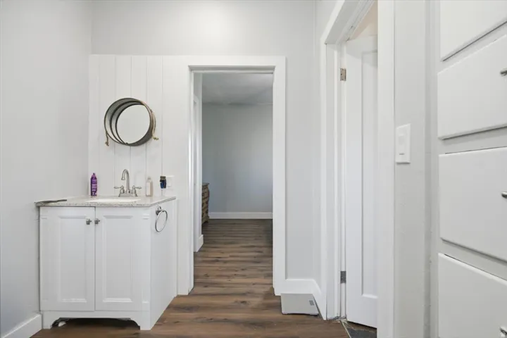 White vanity with a stone-finish countertop and undermount sink