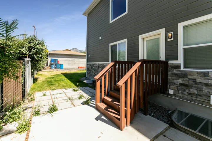 Exterior featuring horizontal siding, stone veneer accents, and a wooden deck with railing